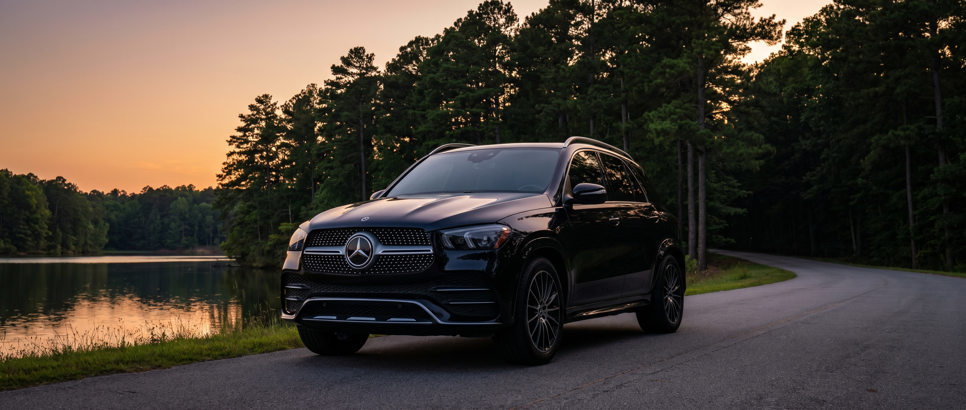 2026 Mercedes-Benz GLE on a Georgia summer road near Lake Lanier, clean exterior against a backdrop of pine trees at dusk